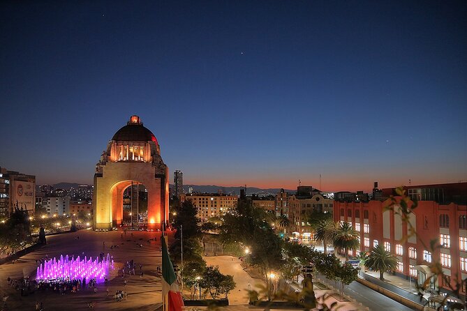 Night Tour of Mexico City Panoramic Ride on a Double-Decker Bus - Monument to Independence (inaugurated 1910): heroes lit in the dark